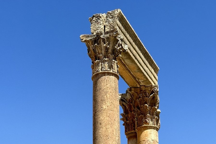 Ancient Corinthian column capitals against a clear blue sky, Jerash, Jordan