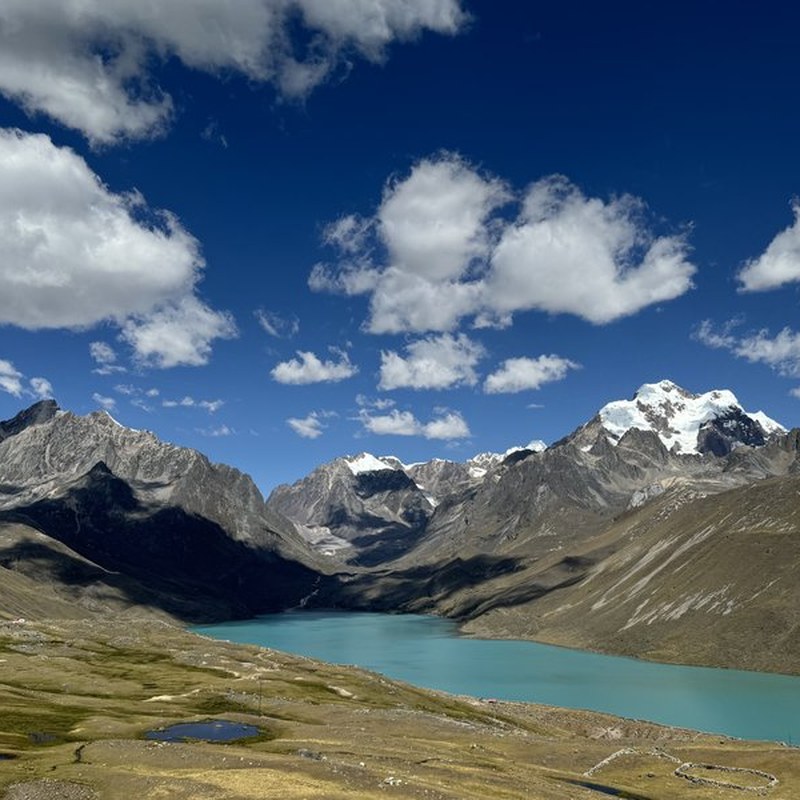 Two community members in traditional dress with Andean mountain backdrop